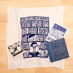 Collection of books and stationery items on a white towel with 'For the Love of Books' design.