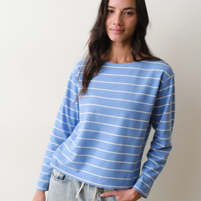 Woman wearing a blue and white striped long sleeved tee against a plain background